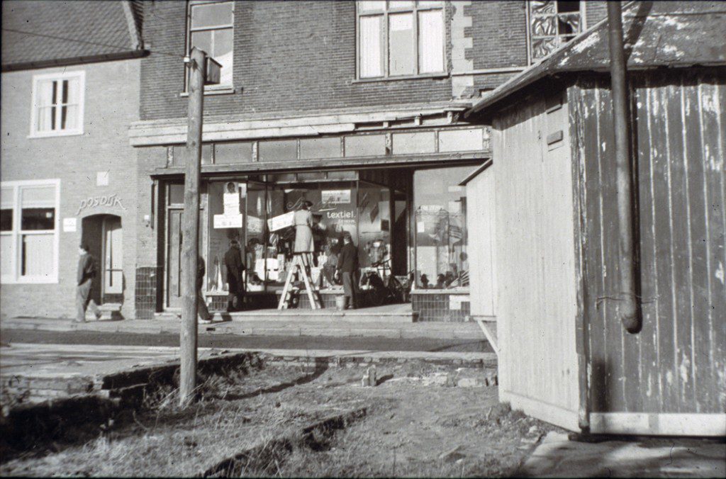 Een van de noodwinkels aan het Plein 1946, nodig om aan winkeliers met verwoeste panden verkoopruimte te verschaffen. Op de achtergrond de winkel van Van der Kraats.