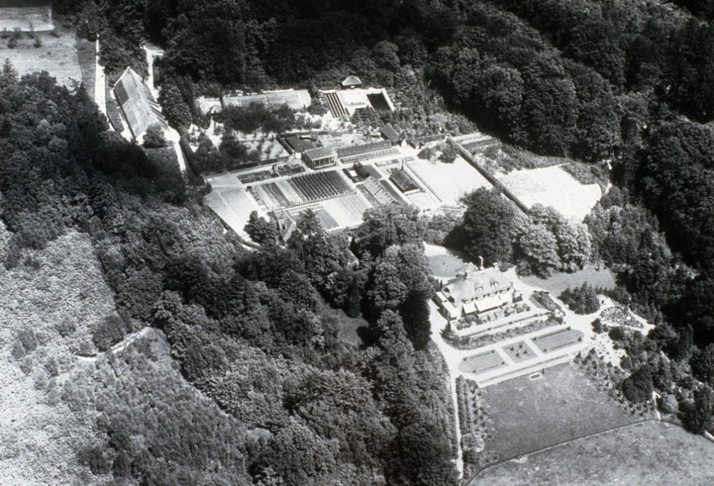 Luchtfoto van huis en nutstuin "Laag Oorsprong". Zichtbaar zijn de kleine orangerie, de broedbakken, het zwembad en de tennisbaan.