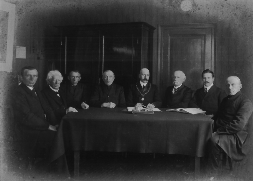 De gemeenteraad van Doorwerth op 13 december 1910 bijeen in de “De 2 Zalmen”, met enige leden van de feestcommissie uit 1898. V.l.n.r.: R. Roosenboom, Baron Van Brakell, (bakker) Johannes van den Berg (bewoner het “Stenenhuis””), Jan van Maanen (boer op “De Noordberg”), burgemeester Jhr. Ferdinand Wttewael van Stoetwegen, gemeentesecretaris A.W.G. Rijnders, D.J. van de Garde, papierfabrikant Gerrit Schut. 