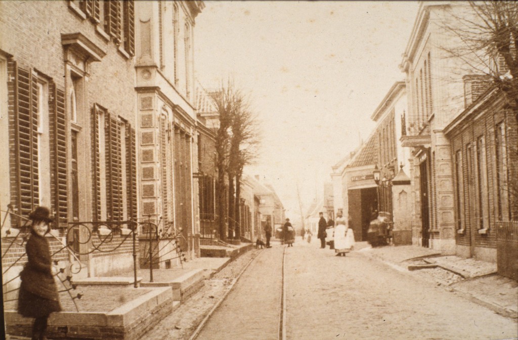 Rechts, achter de dorpspomp, hotel “De Reizende Man" met de postschuur.